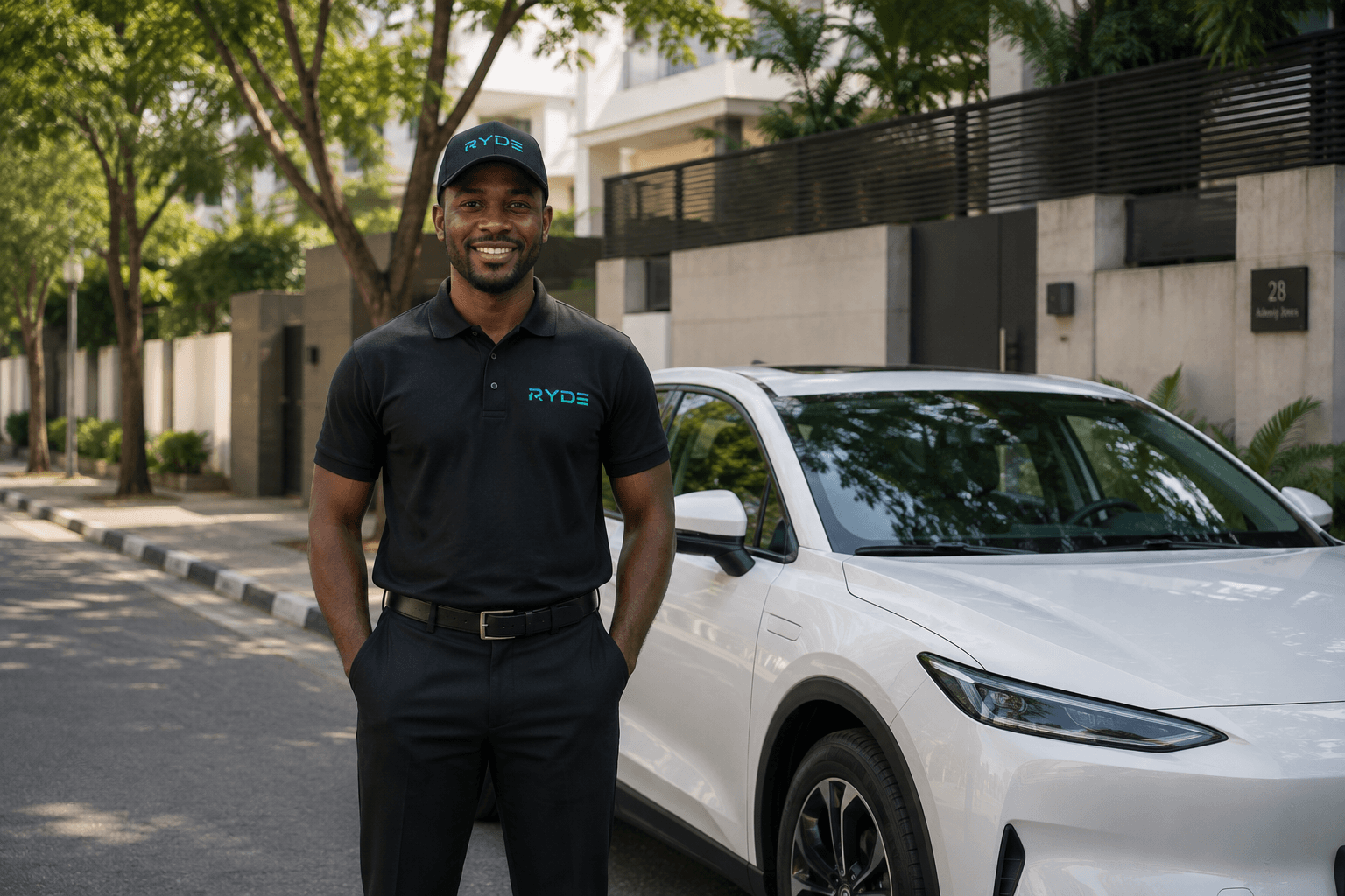 A RYDe driver in branded uniform standing beside a clean white electric car on a tree-lined street in daylight.